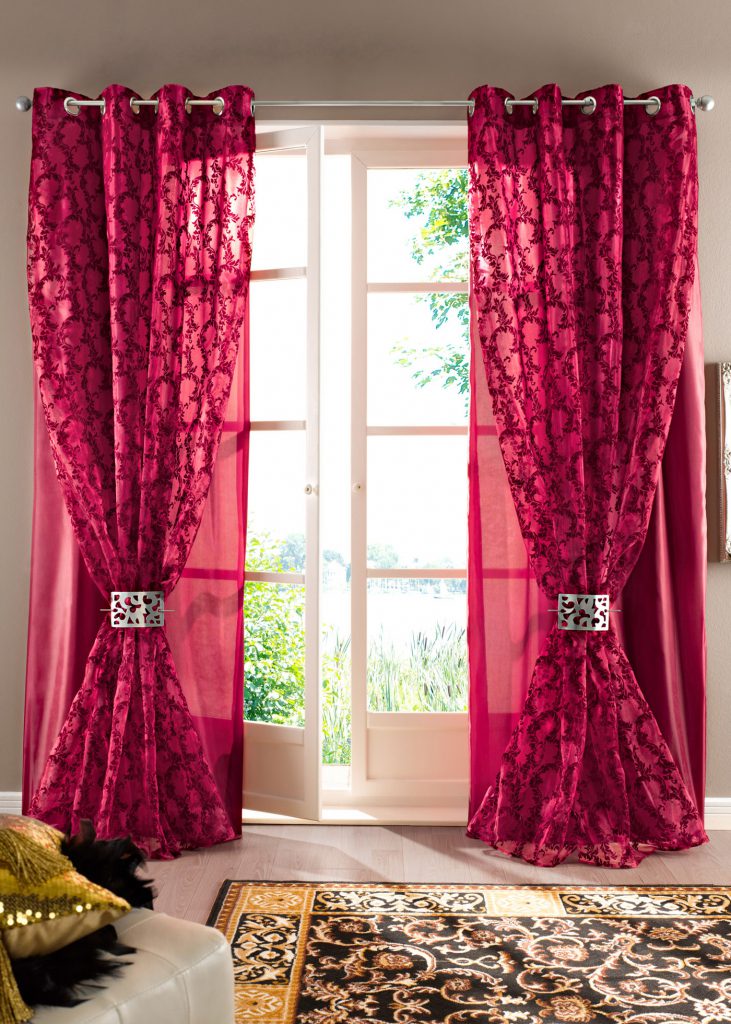 Bright scarlet curtains on the grommets and tulle in the living room