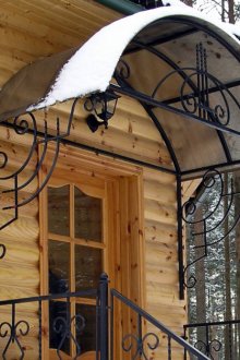 Arched visor of a wrought-iron and polycarbonate country house