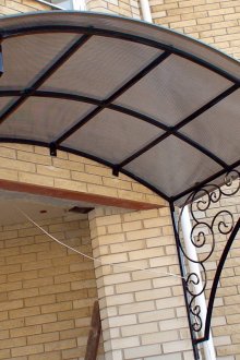 Arched visor made of forged elements and polycarbonate