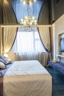 Black glossy ceiling in a bright bedroom