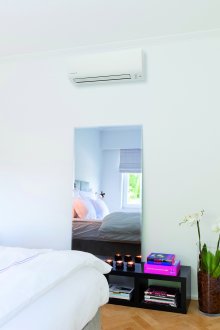 Бял климатик в спалня с бели стени