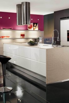 Black and white minimalistic kitchen with an island with a pink accent on the wall.