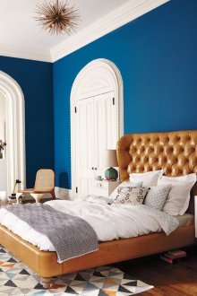Brown leather bed in a white and blue bedroom