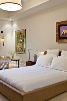 Brown leather bed in a beige and white bedroom