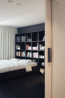Minimalist black and white bedroom with bookcase.