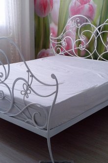 Интериор на спалнята с бяло легло от ковано желязо