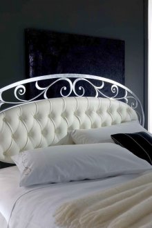 Hermosa cama de hierro forjado en el dormitorio.
