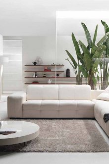 Аксесоари и бял ъглов диван в дневната в модерен стил