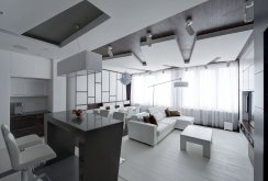 White and black furniture in the interior of the living room-kitchen