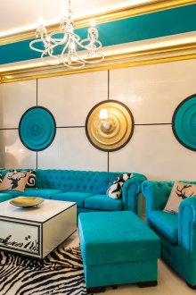 Изумруден, златист, бял и черен цвят в интериора на хола