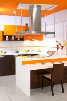 Оранжеви, бели и кафяви цветове в интериора на кухнята с полуостров