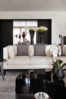 Interior de sala de estar en blanco y negro con detalles en gris y beige.