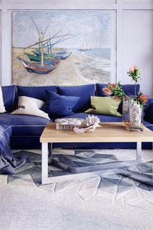Син ъглов диван и бял шезлонг в хола-кухнята