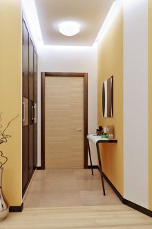 Large lamp and lights around the perimeter of the ceiling in the white and yellow hallway