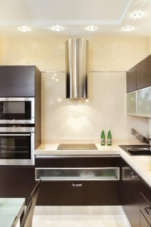 Бежова и кафява кухня с маса за хранене.