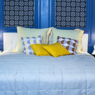 Bantal kuning dan seprai biru di bilik tidur