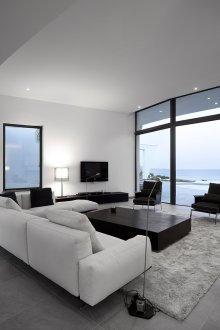 Черно-бяла всекидневна със сив килим.