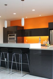 Оранжева стена в черно-бяла кухня