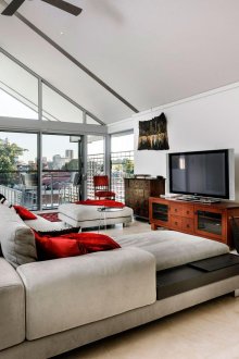 Червени и кафяви акценти в светла всекидневна