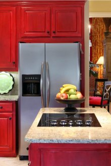 Graue Arbeitsplatte und Schutzblech in einer roten Küche