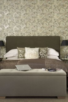Katil kelabu gelap dan meja kaca di dalam bilik tidur
