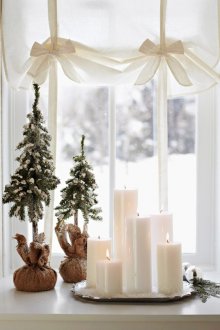 Коледни свещи и коледни елхи на прозореца