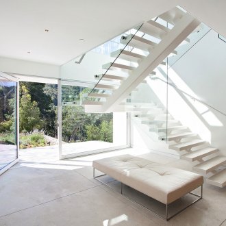 Бяло стълбище със стъклени парапети в интериора