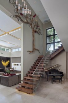 Дървено стълбище със стъклен парапет във вътрешността на къщата