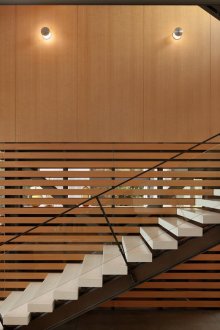 Черно-бяло стълбище със стъклен парапет във вътрешността на къщата