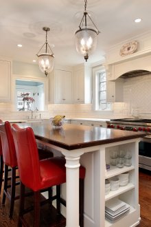 Червени столове в кафява и бяла кухня