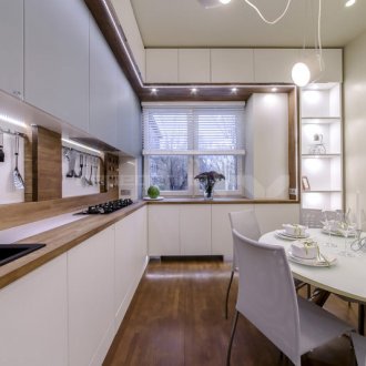 Brown and white kitchen with dining table.