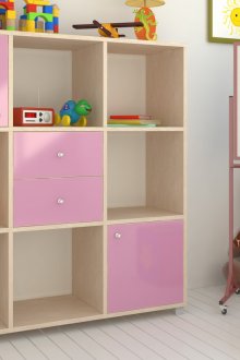 Бежово-розово шкафче за книги с чекмеджета в детската стая