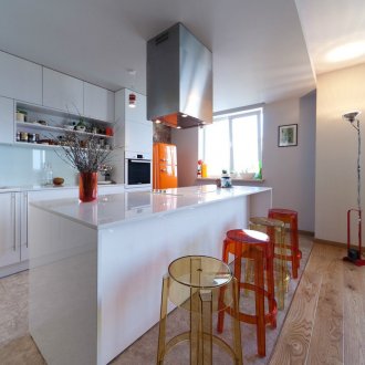 Бяла кухня с червени и оранжеви акценти