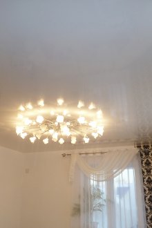 Малък полилей с бял опънат таван в хола