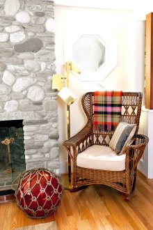 Красив плетен люлеещ се стол в хола с камина