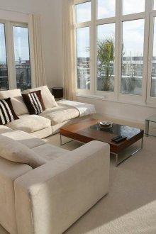 Ъглов диван в хола с два прозореца