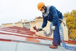 The process of painting the roof with a spray gun