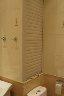 Fridge under the window with plastic doors