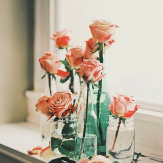 Рози във ваза на перваза на прозореца