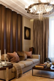 Кафяво-бежов дизайн на хол с висящ обемен полилей