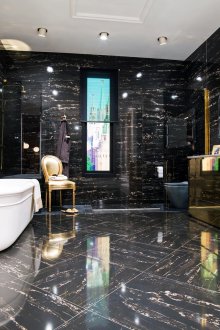 Черна плочка с шарки със златни мебели в банята