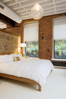 Червената тухла придава на спалнята уют и динамика