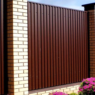 Гофрирана ограда с тухлени стълбове