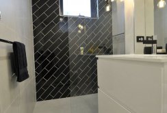 Laying black tiles diagonally on the bathroom wall