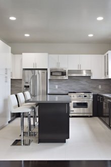 Черно-бяла кухня със сиви плотове.