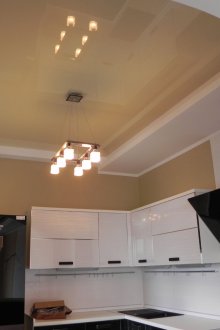 Полилей под лъскав кремаво бял таван за разтягане в кухнята