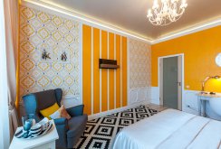 A bright combination of different wallpapers with orange elements in the bedroom