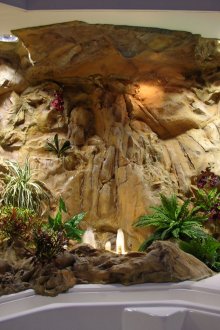 Декоративен водопад и изкуствени растения в интериора на банята