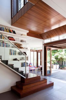 Дървено кафяво стълбище със стъклен парапет.