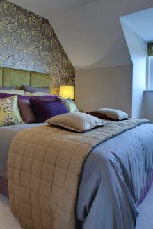 Cetakan abstrak pada kertas dinding, bantal dan langsir mencipta perpaduan gaya di dalam bilik tidur